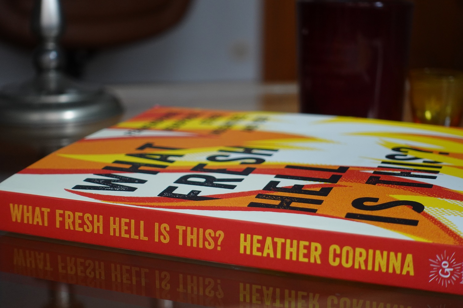 Heather Corinna's book is lying on a table. The cover has red, orange, yellow and white flames.